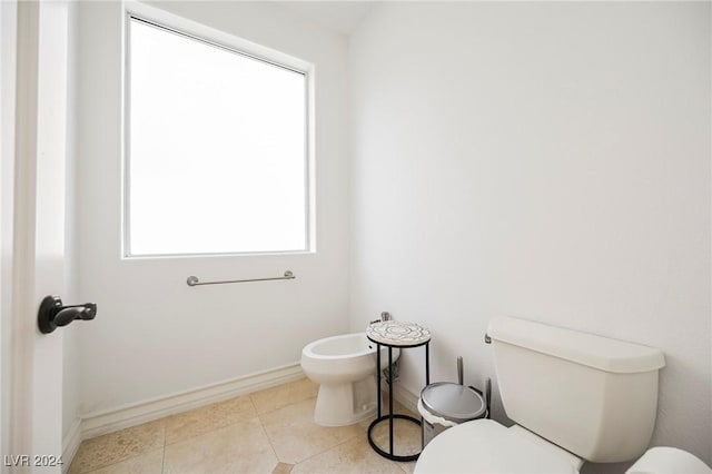 bathroom with a bidet, a healthy amount of sunlight, and toilet