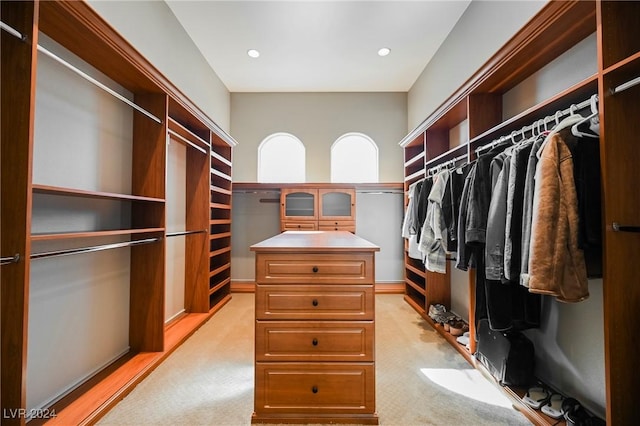 walk in closet featuring light colored carpet