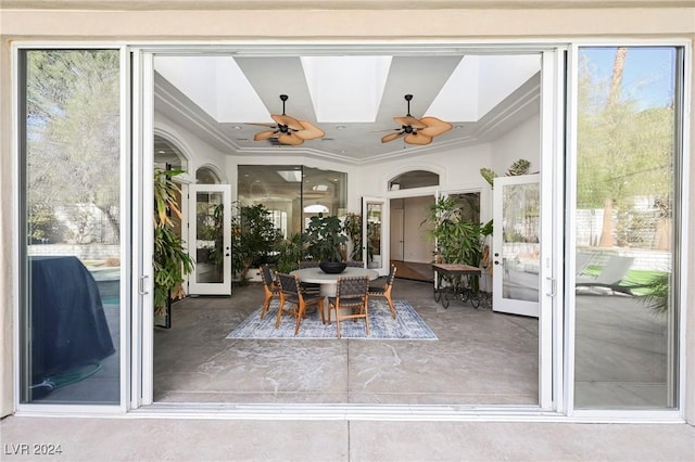 sunroom / solarium featuring french doors, ceiling fan, a skylight, and a wealth of natural light