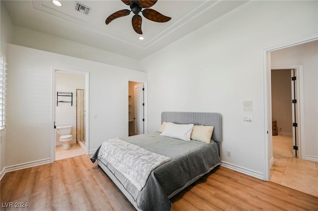 bedroom featuring ceiling fan, ensuite bath, and light hardwood / wood-style flooring