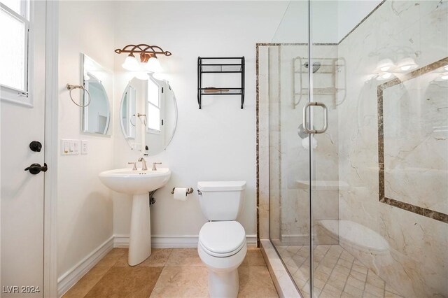 bathroom featuring sink, a shower with shower door, tile patterned floors, and toilet