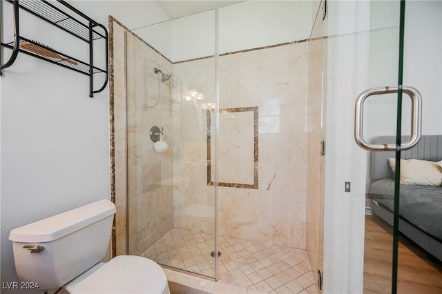 bathroom featuring walk in shower, toilet, and hardwood / wood-style flooring