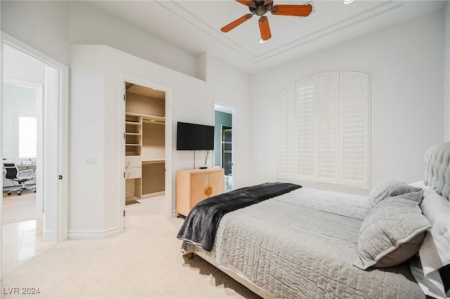 carpeted bedroom with a spacious closet, a closet, and ceiling fan