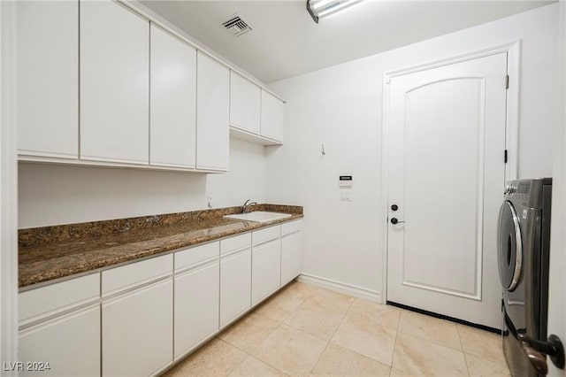 laundry room featuring cabinets, washer / dryer, sink, and light tile patterned floors