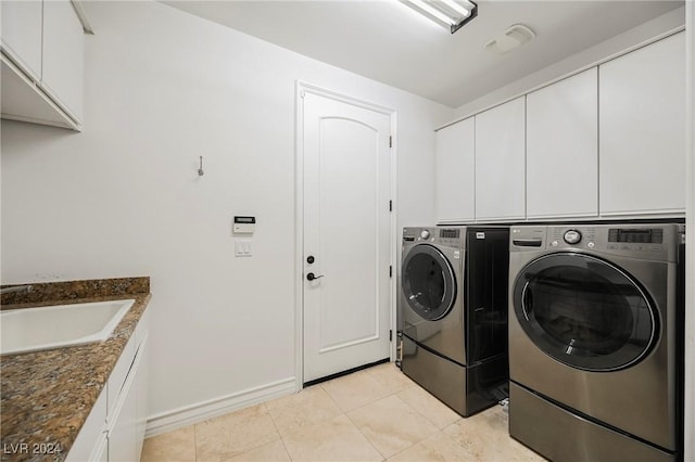 clothes washing area featuring cabinets, washing machine and dryer, sink, and light tile patterned floors