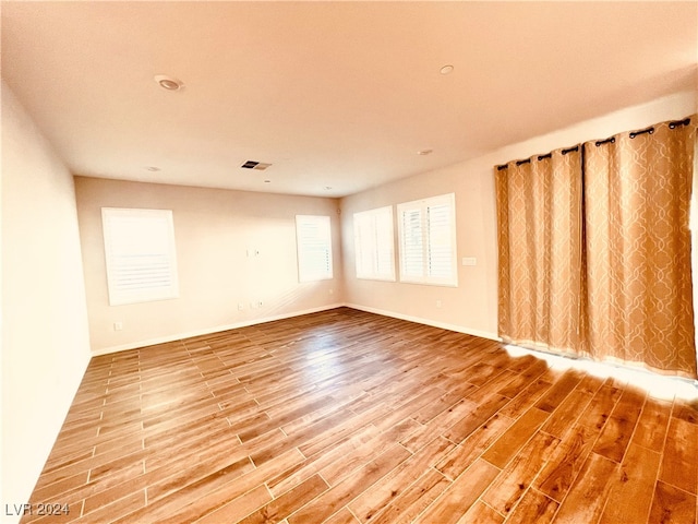 empty room with wood-type flooring and a textured ceiling