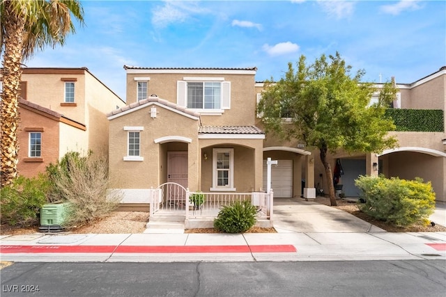 mediterranean / spanish house featuring a garage and central AC unit