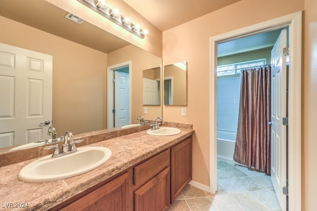 bathroom featuring tile patterned floors, vanity, and shower / bath combo with shower curtain