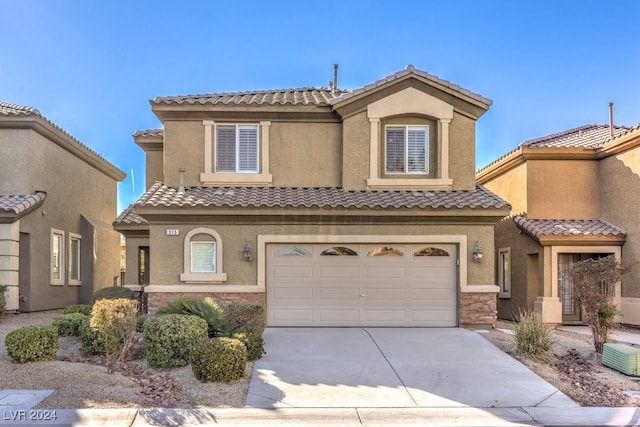 mediterranean / spanish-style house featuring cooling unit and a garage