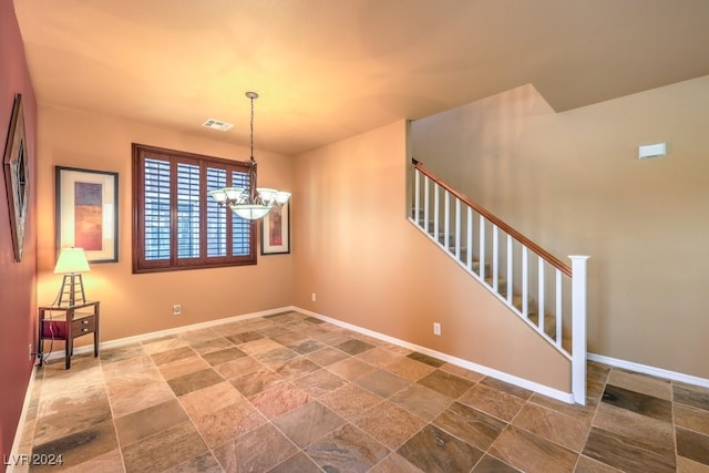 unfurnished room with a chandelier