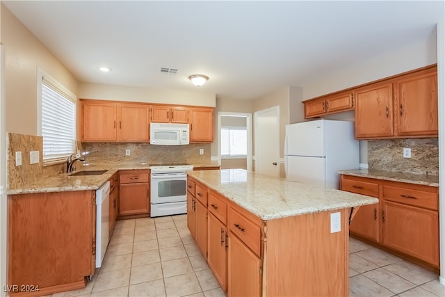 kitchen featuring plenty of natural light, a center island, white appliances, and sink