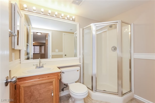 bathroom featuring toilet, vanity, tile patterned floors, and an enclosed shower