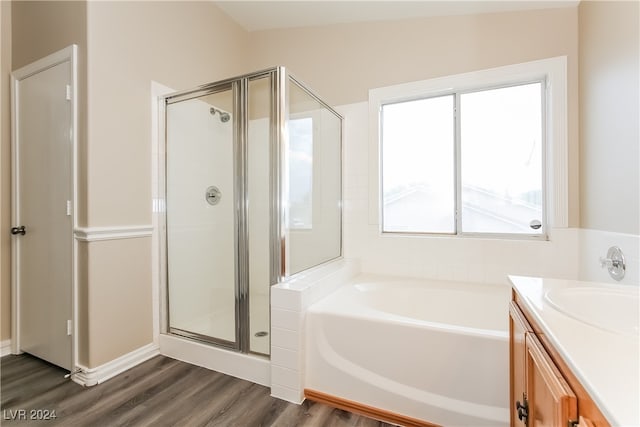 bathroom featuring hardwood / wood-style floors, vanity, separate shower and tub, and lofted ceiling