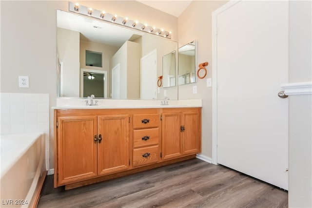 bathroom featuring a tub to relax in, vanity, and hardwood / wood-style flooring