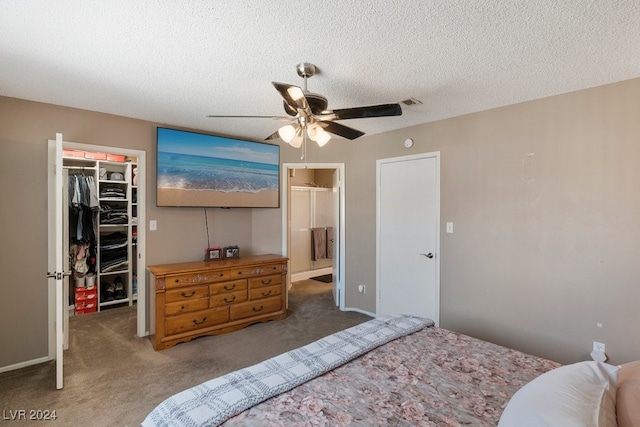 bedroom featuring ceiling fan, ensuite bathroom, a textured ceiling, a closet, and dark carpet