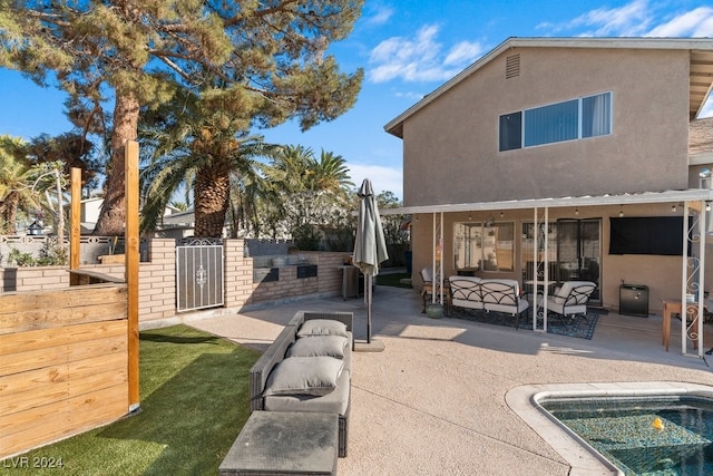 rear view of house featuring outdoor lounge area, a patio, and an outdoor kitchen