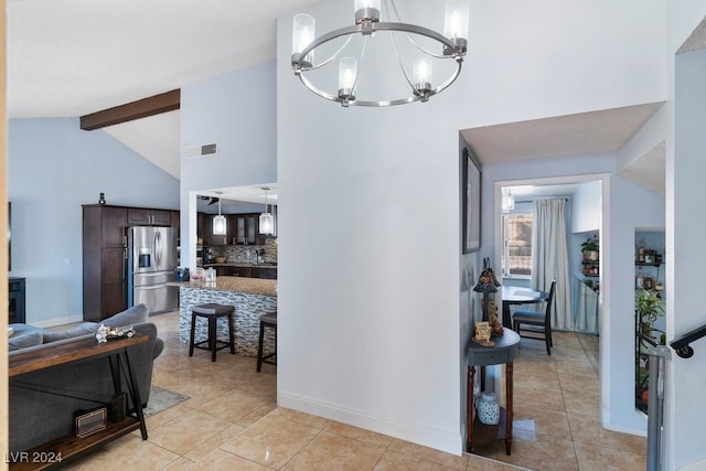 hall with light tile patterned floors, lofted ceiling with beams, a textured ceiling, and an inviting chandelier