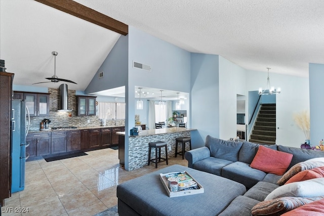 tiled living room featuring beamed ceiling, ceiling fan with notable chandelier, a textured ceiling, and high vaulted ceiling