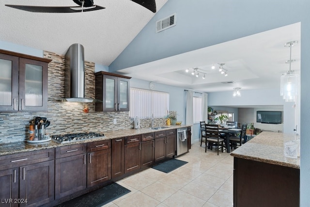 kitchen with dark brown cabinetry, sink, stainless steel appliances, and wall chimney range hood