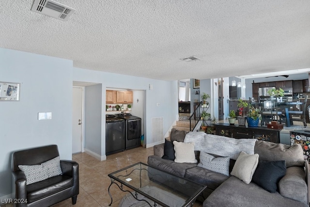 tiled living room featuring a textured ceiling and washing machine and clothes dryer