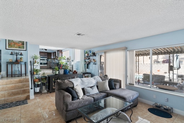 living room with light tile patterned flooring and a textured ceiling