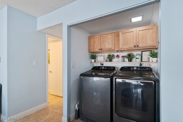 washroom with light tile patterned floors, a textured ceiling, and separate washer and dryer