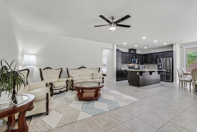 living room with ceiling fan, sink, and light tile patterned flooring