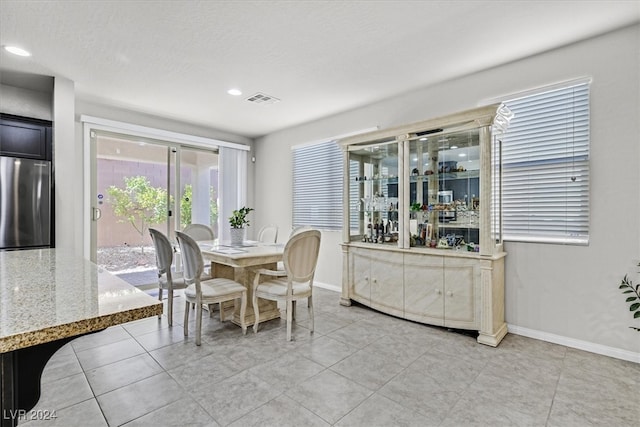 dining room with light tile patterned floors and a textured ceiling