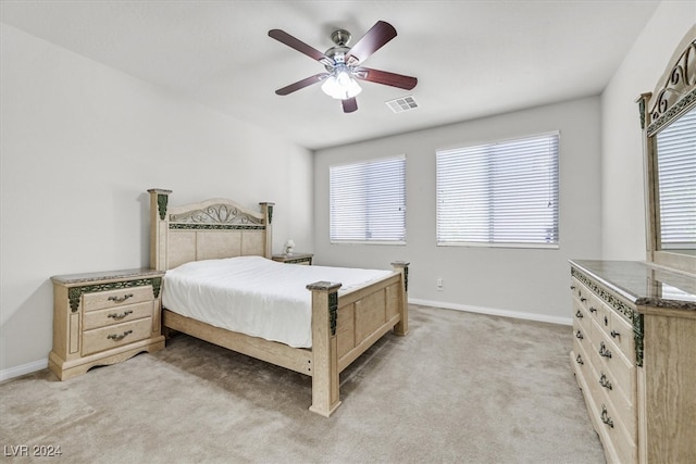 bedroom featuring multiple windows, ceiling fan, and light colored carpet