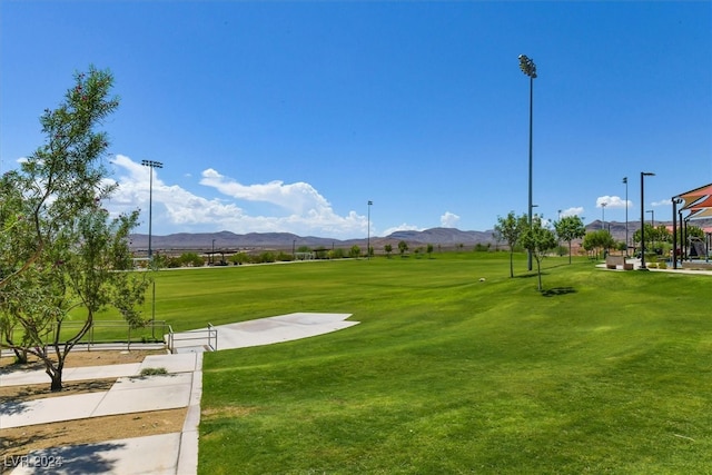 surrounding community with a mountain view and a yard