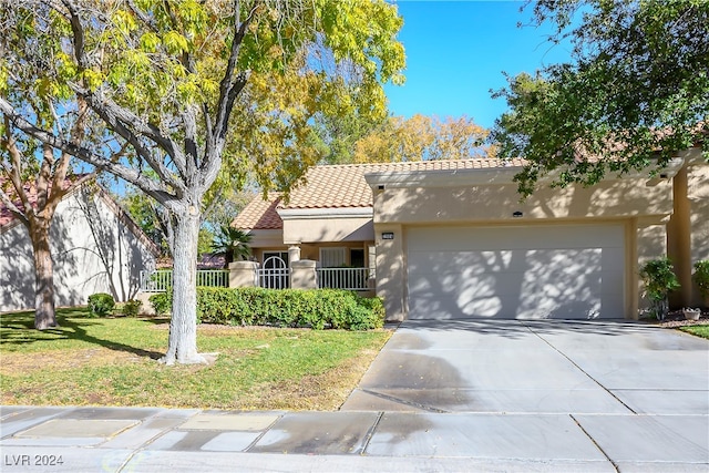 mediterranean / spanish house with a front yard and a garage