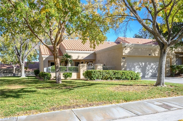 mediterranean / spanish-style house featuring a front yard and a garage