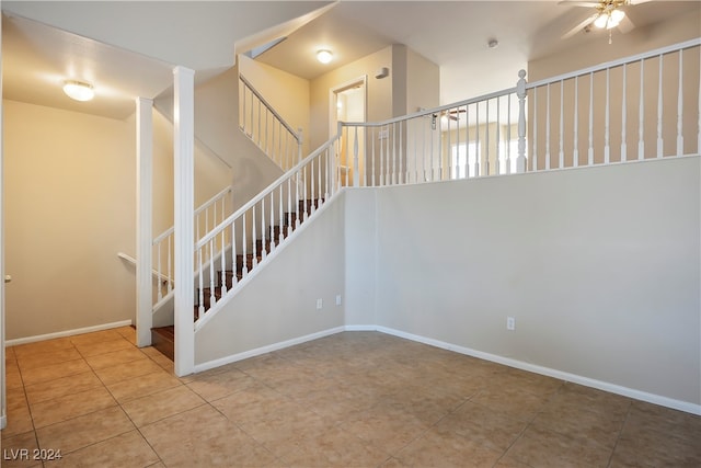 staircase featuring tile patterned flooring and ceiling fan