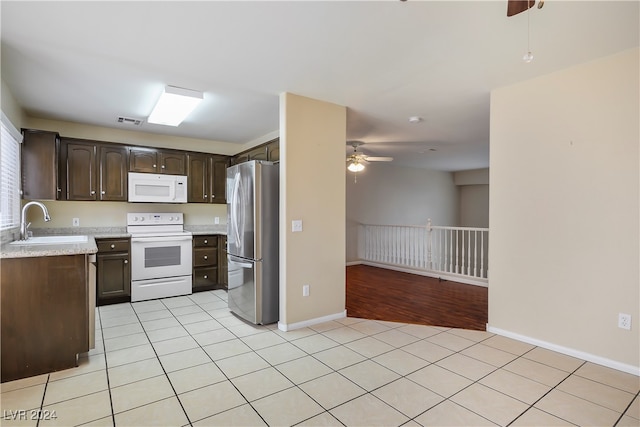 kitchen with dark brown cabinetry, ceiling fan, sink, white appliances, and light wood-type flooring