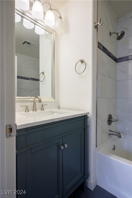 bathroom with tiled shower / bath combo and vanity