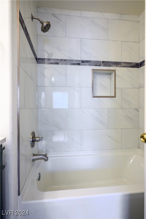 bathroom with tiled shower / bath combo and vanity