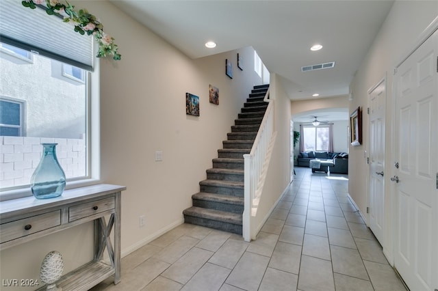 staircase featuring tile patterned floors and ceiling fan