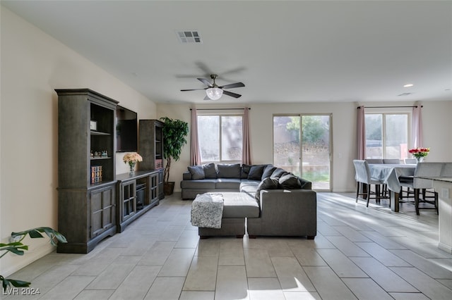 tiled living room with ceiling fan and plenty of natural light