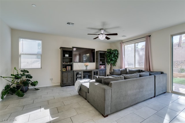 tiled living room featuring ceiling fan