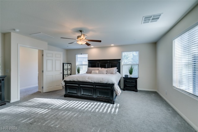 carpeted bedroom with multiple windows and ceiling fan