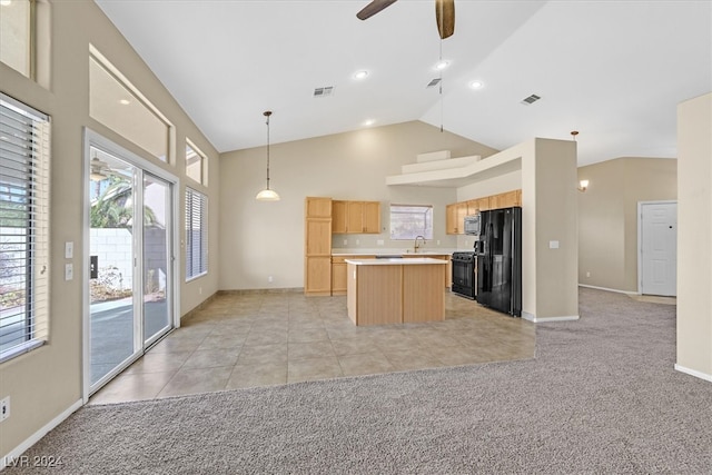 kitchen with black appliances, ceiling fan, a center island, and light carpet