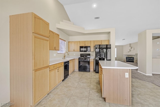 kitchen featuring light brown cabinets, black appliances, sink, vaulted ceiling, and light colored carpet