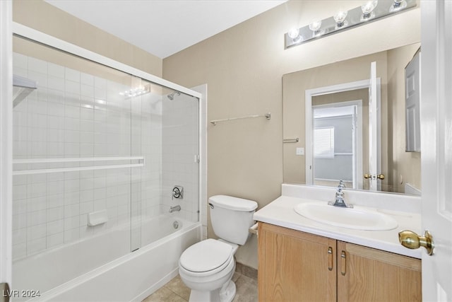 full bathroom featuring tile patterned floors, vanity, toilet, and bath / shower combo with glass door