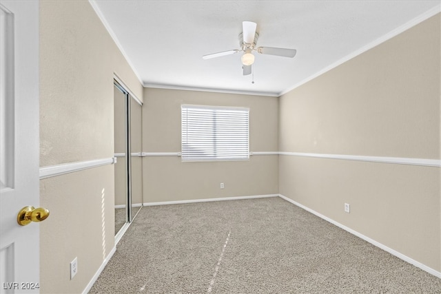 unfurnished bedroom with carpet flooring, ceiling fan, a closet, and ornamental molding