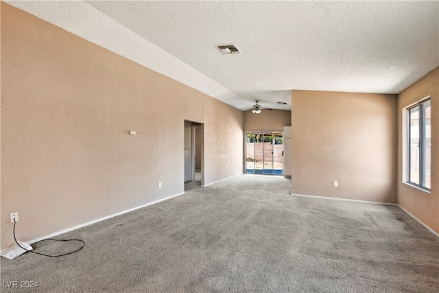 empty room with carpet flooring, ceiling fan, a healthy amount of sunlight, and lofted ceiling