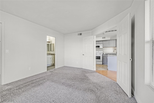 unfurnished living room featuring light carpet