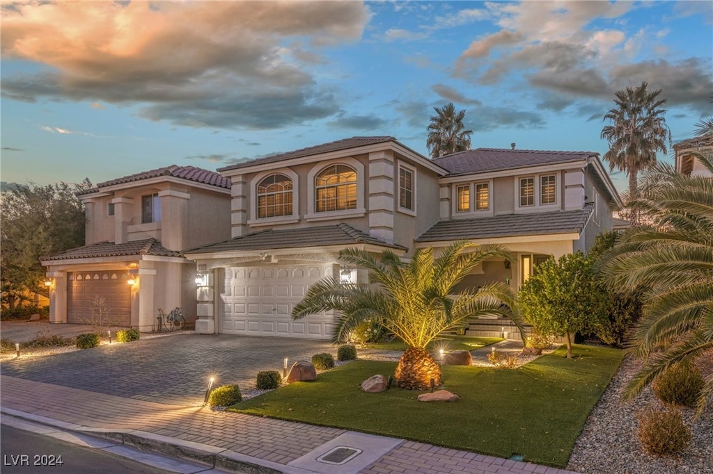 mediterranean / spanish-style house with a lawn and a garage