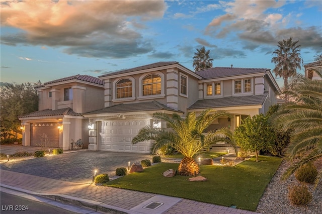 mediterranean / spanish-style house with a lawn and a garage