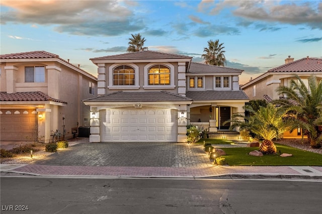 mediterranean / spanish-style house with cooling unit and a garage