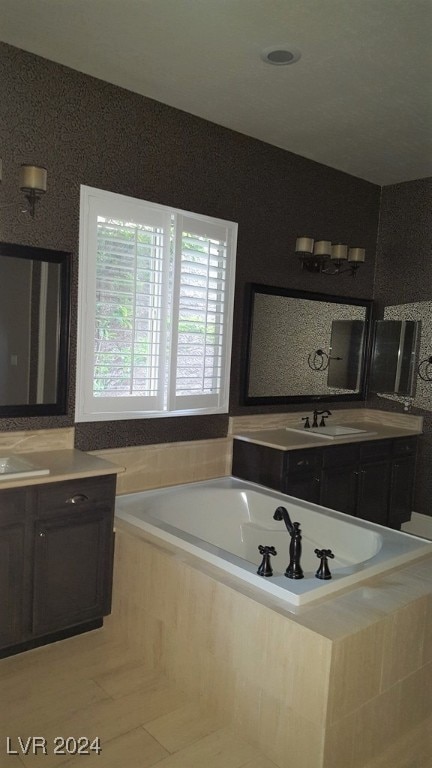 bathroom with vanity and tiled bath